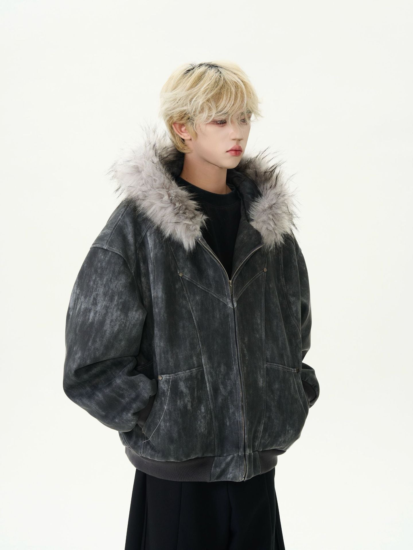 Person wearing a dark gray jacket with fur trim on a white background
