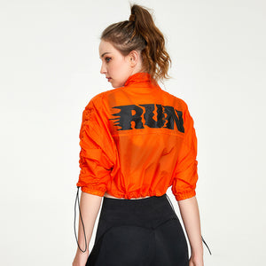 Person wearing an orange jacket with 'RUN' printed on the back against a white background