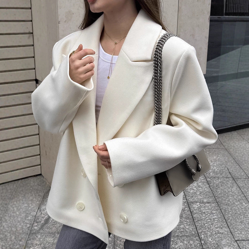 Person wearing a white blazer with a neutral background