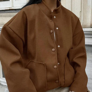 A person wearing a brown vintage woolen stand collar coat with button closures and loose fit.