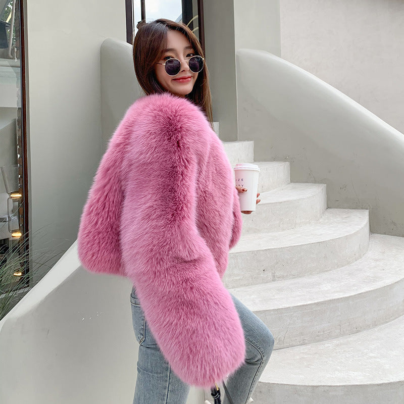 Person wearing a pink fluffy coat standing on a staircase.