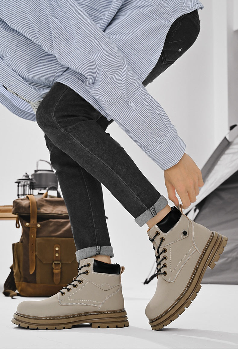 Person wearing beige boots with brown soles, sitting next to a brown backpack.