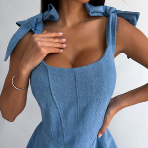 Blue dress with bow shoulders on a plain background