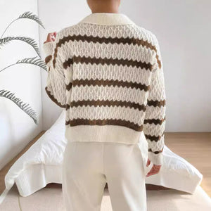 Person wearing a white and brown striped sweater in a minimal indoor setting