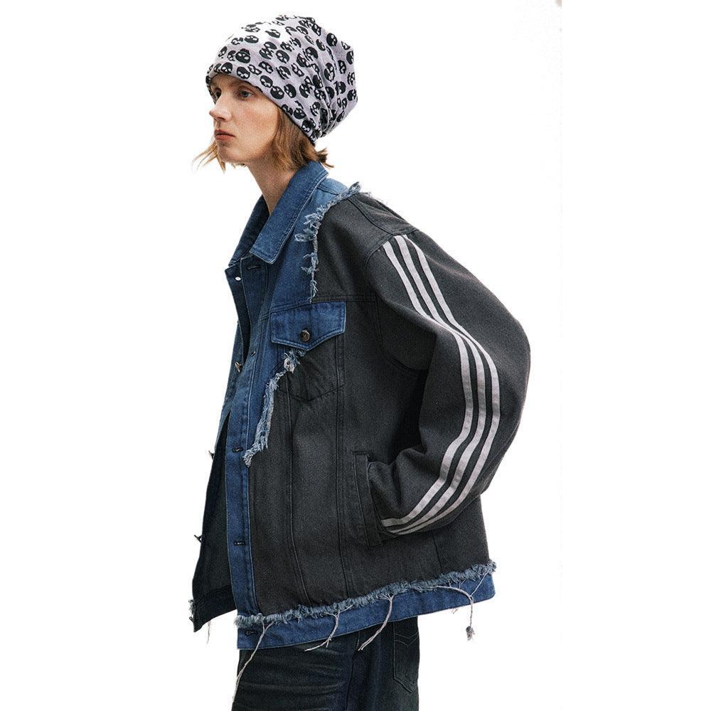 A person wearing an irregular patchwork coat with color contrasts, featuring a denim blue and black design.