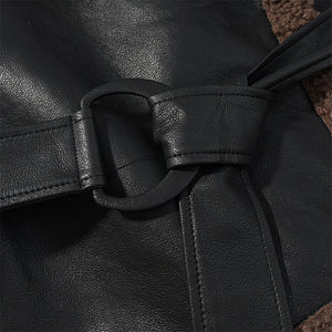 Close-up of a black leather belt with a buckle on a dark background