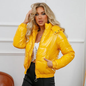 A woman wearing a yellow hooded jacket with a splash-proof surface, paired with a white top and black pants.