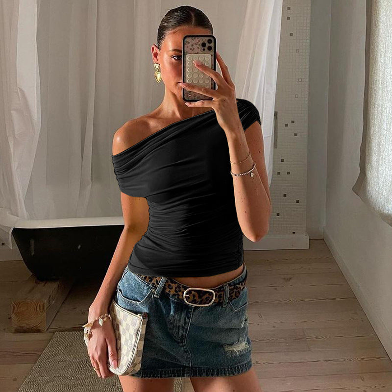 A woman wearing a yellow sleeveless top with a diagonal collar, paired with a denim skirt and carrying a white purse.