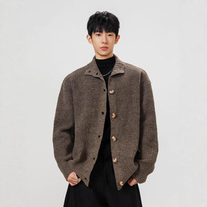 Person wearing a brown textured jacket on a plain background