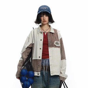A person wearing a beige and brown color patchwork denim jacket with an irregular design, paired with a red top and blue jeans. Accessories include a cap, necklaces, and carrying a net bag