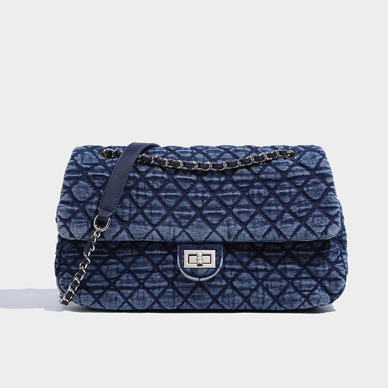 A large-capacity denim women's commuter shoulder messenger bag with chain details and a lock closure, in a gray and blue color scheme.