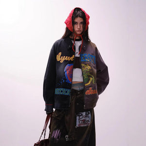A person wearing a unisex, loose fit jacket with multicolored urban graffiti designs.