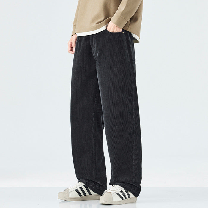 Person wearing black wide-leg pants and white sneakers with black stripes on a light gray background