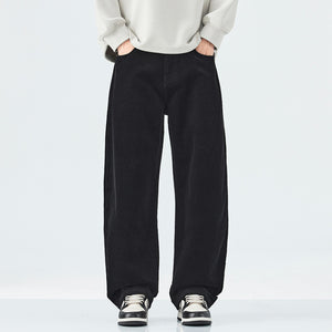 Person wearing black wide-leg pants and a light-colored sweater on a white background