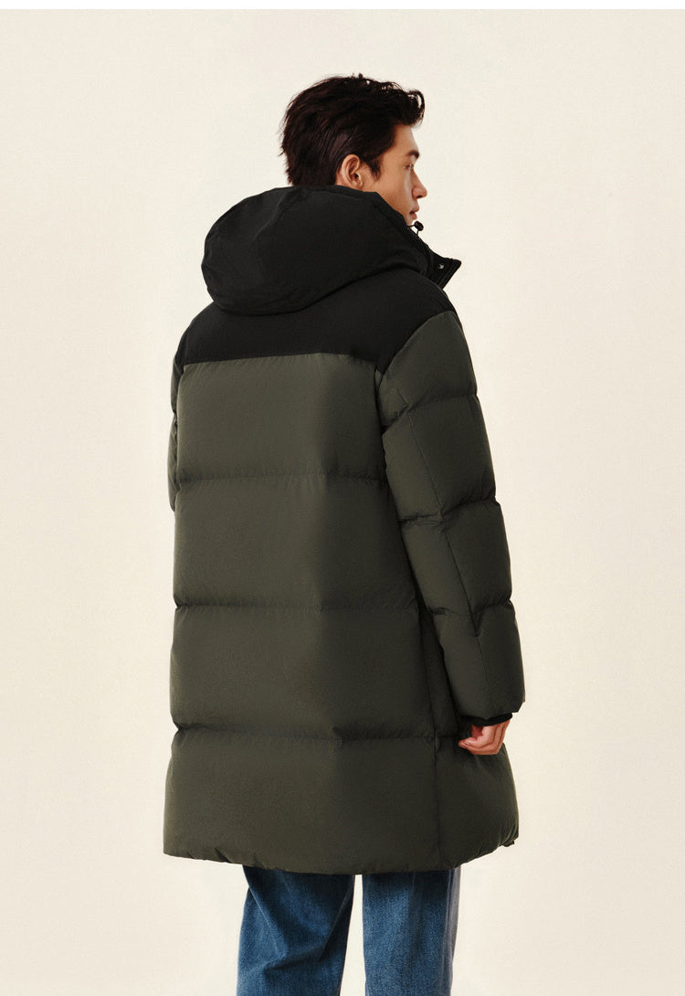 Man wearing a green and black puffer coat on a beige background