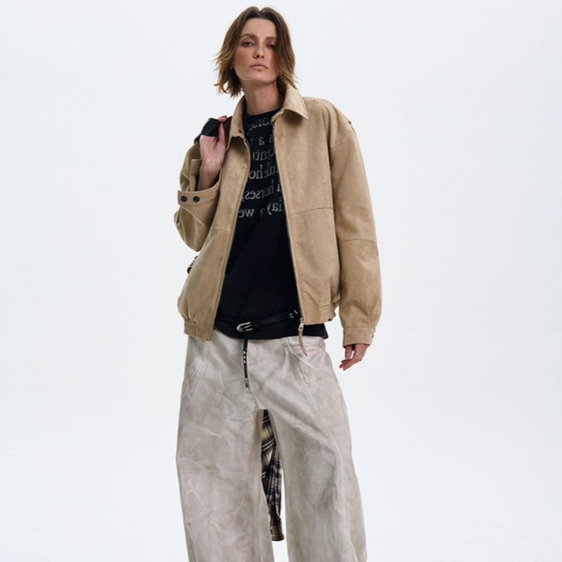 Person wearing a beige jacket and light-colored pants on a white background