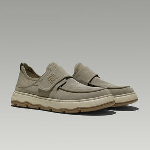Pair of beige slip-on shoes on a light gray background