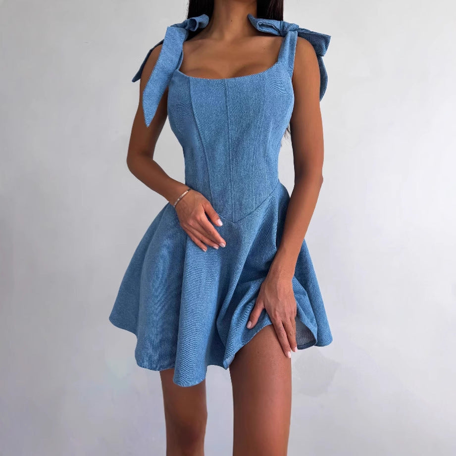 Blue dress with bow straps worn by a person on a plain background