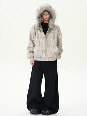 Person wearing a fur-lined hooded jacket and black pants on a white background