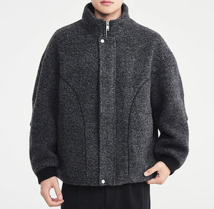 Person wearing a gray textured jacket on a white background