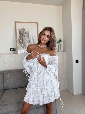 Elegant Ruffled Long - Sleeve Floral Mini Dress - MRC STOREDressMRC STOREA woman standing in a living room wearing an off - shoulder, ruffled, long - sleeve, floral mini dress.MRC STORECJLY219647804DWFloralL