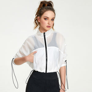 Woman wearing a white sheer jacket with black accents on a white background