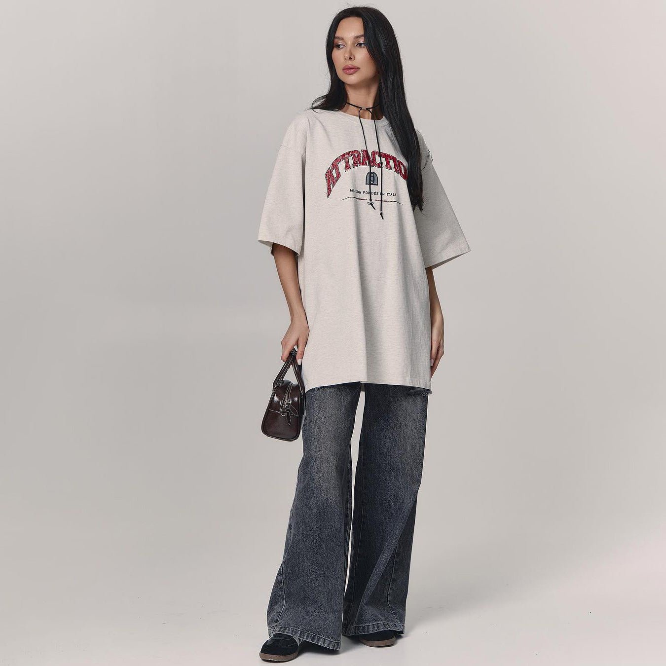 Letter T-Shirt - Loose Shoulder Printed Top - MRC STORET-ShirtsMy StoreWoman wearing a beige oversized t-shirt with text and dark jeans on a plain backgroundMRC STORECJCS204529003CXGray And WhiteL