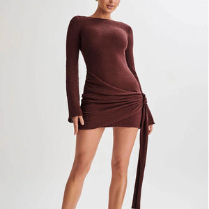 A model wearing a brown, V-shaped backless short dress with 3D effect pattern and a hip-hugging skirt.