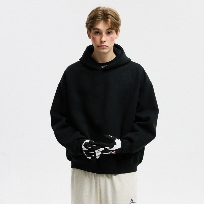 Person wearing a black hoodie with a white graphic on a plain background