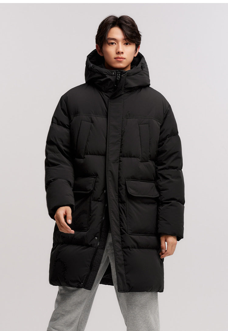 Person wearing a black puffer coat on a light gray background