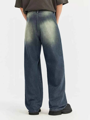 Person wearing blue acid-wash jeans on a white background