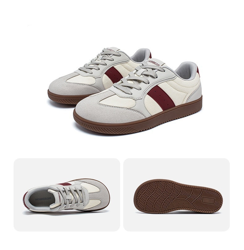 White and burgundy sneakers with a close-up of the sole on a white background