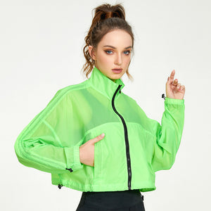 Woman wearing a bright green jacket on a white background