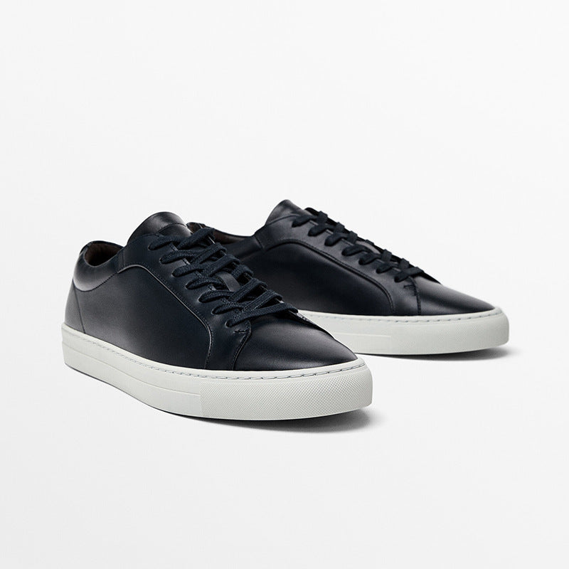 Black sneakers with white soles on a light gray background
