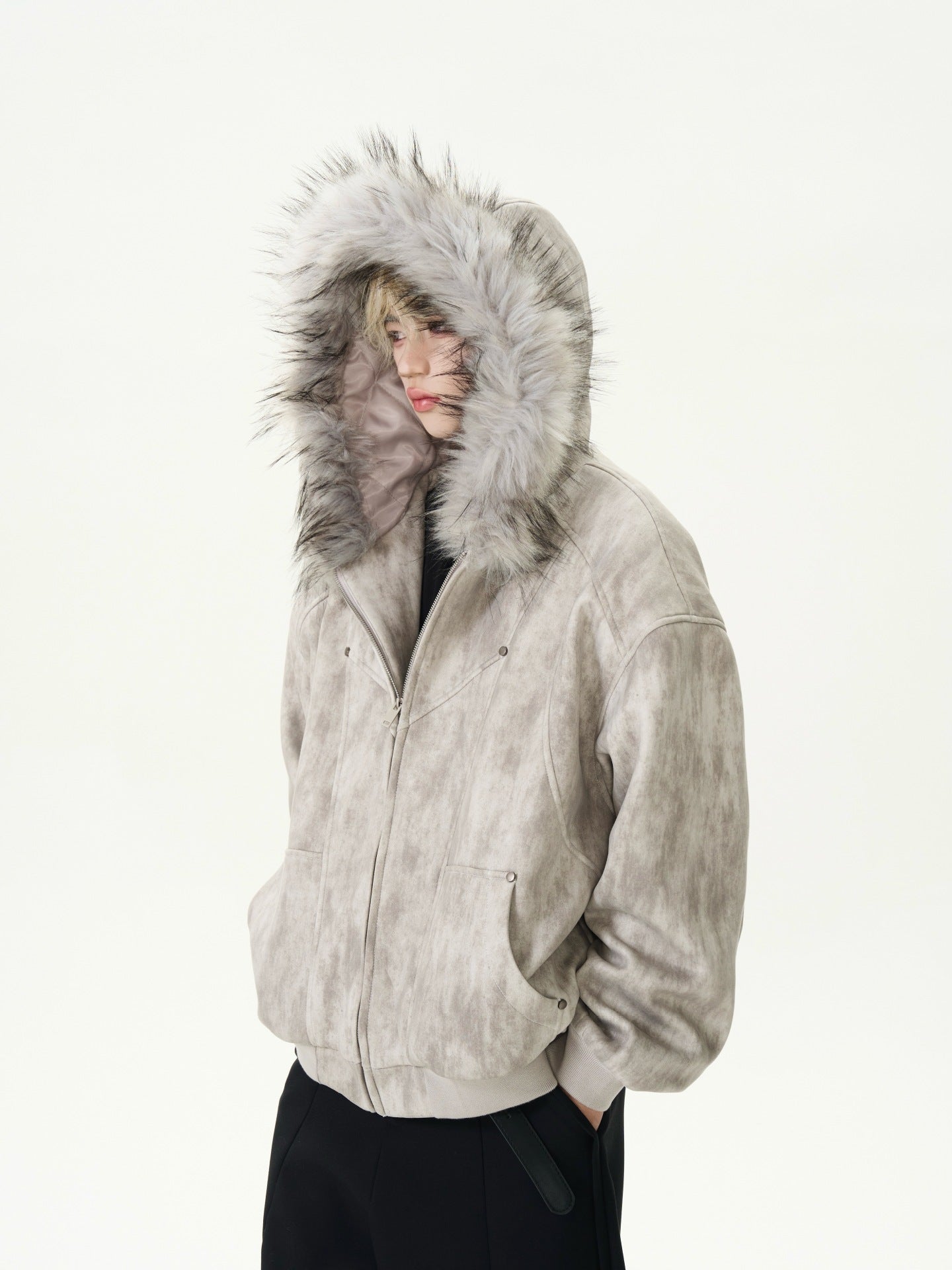 Person wearing a beige jacket with a fur-lined hood on a white background