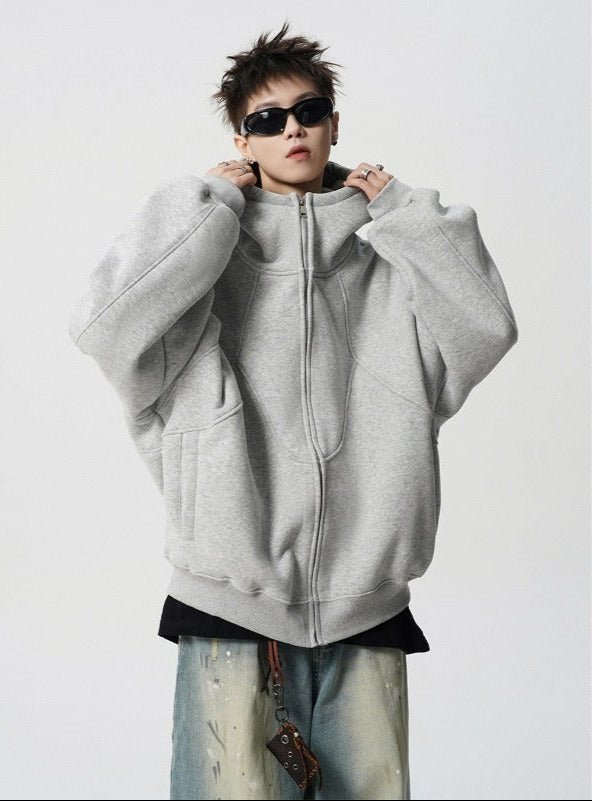 Person wearing a gray hoodie with sunglasses on a white background