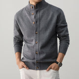 Gray cardigan with brown buttons worn by a person on a light gray background