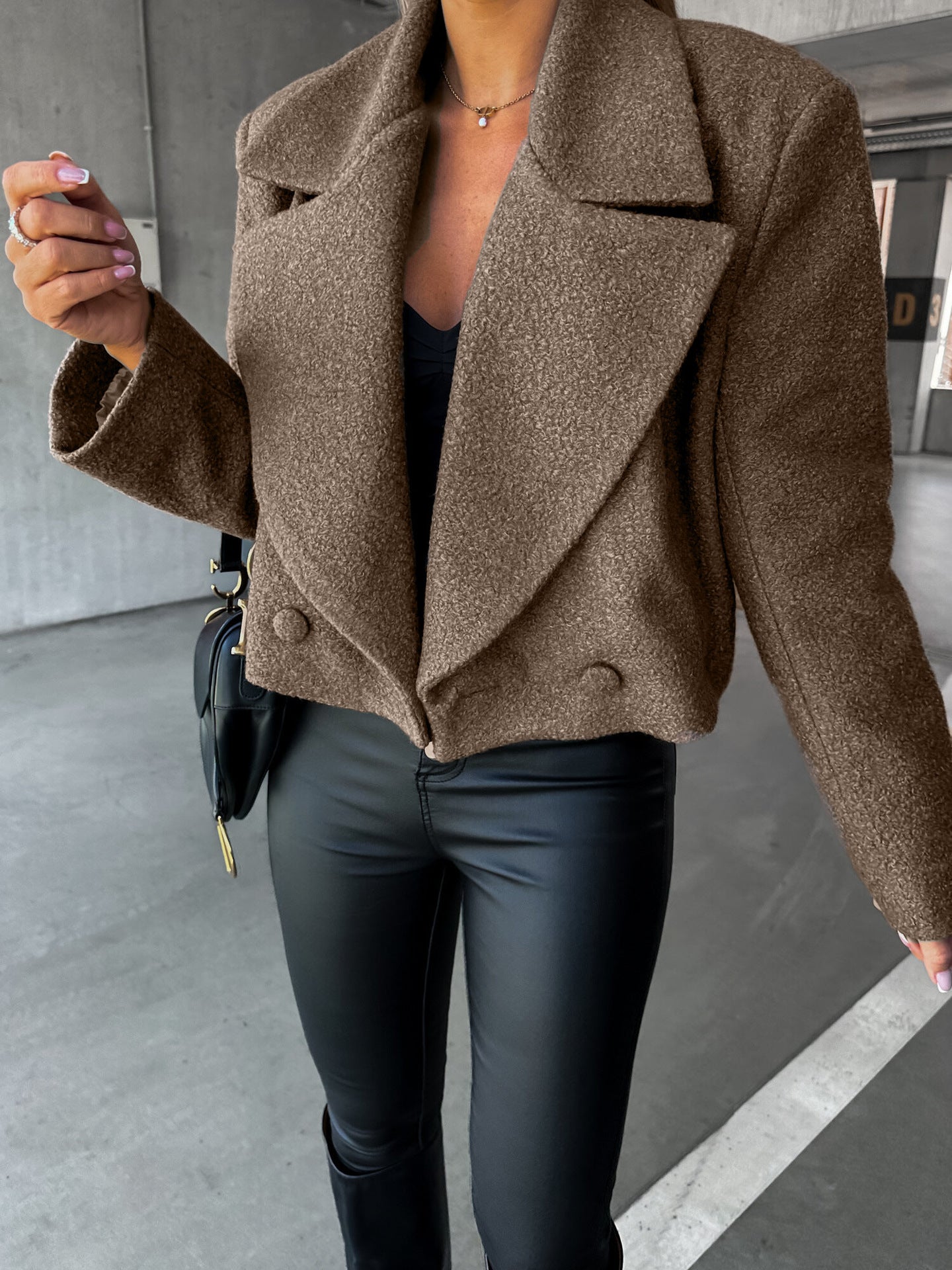 Person wearing a brown coat and black pants in an urban setting