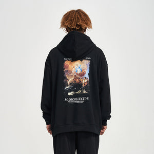 Person wearing a black hoodie with a colorful graphic and text on the back against a white background