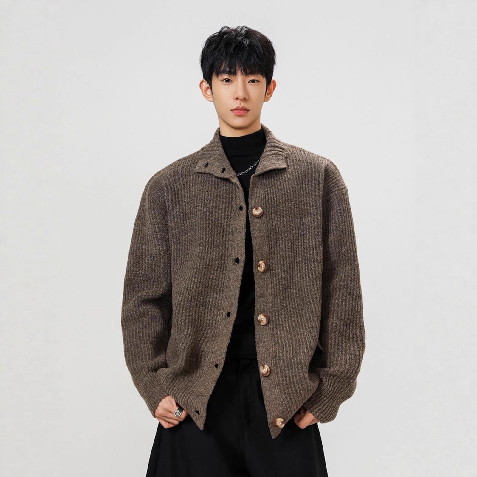 Person wearing a brown textured jacket on a plain background