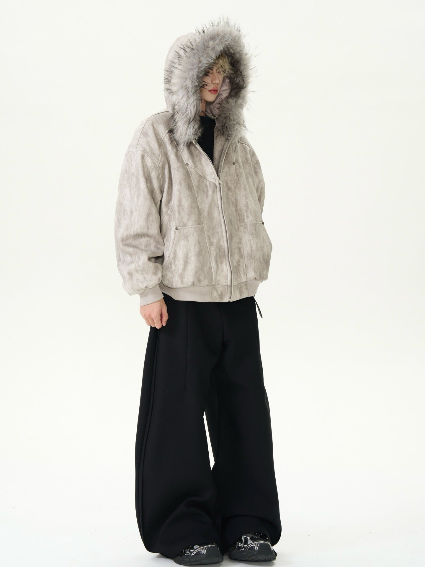 Person wearing a beige hooded jacket with fur lining on a white background