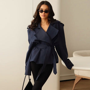 Woman wearing a navy blue coat in an indoor setting
