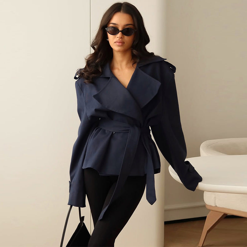Woman wearing a navy blue coat in an indoor setting