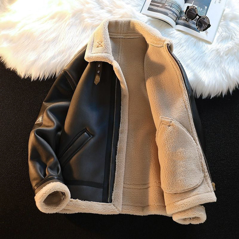 Folded beige and black jacket on a fluffy white surface