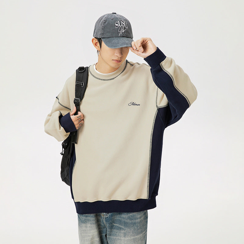 Person wearing a beige and navy sweater with a gray cap, holding a black backpack on a white background