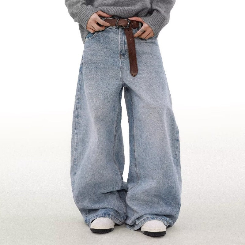 Person wearing wide-leg jeans with a brown belt on a white background