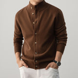 Brown button-up sweater worn by a person on a gray background