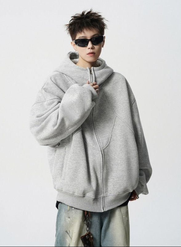 Person wearing a gray hoodie and sunglasses on a white background