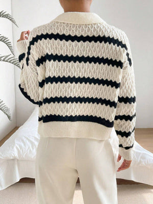 Person wearing a white and navy striped sweater with a neutral background