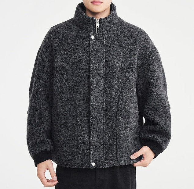 Person wearing a gray textured jacket on a white background